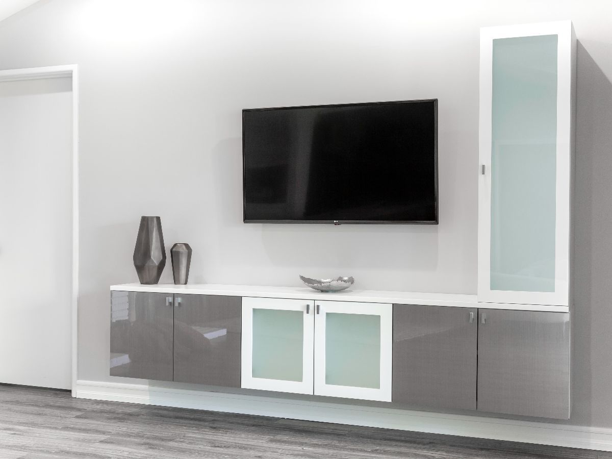 Gray walk-in closet with neatly organized clothing, including shirts, pants, and accessories. Neutral tones and a modern design are featured.