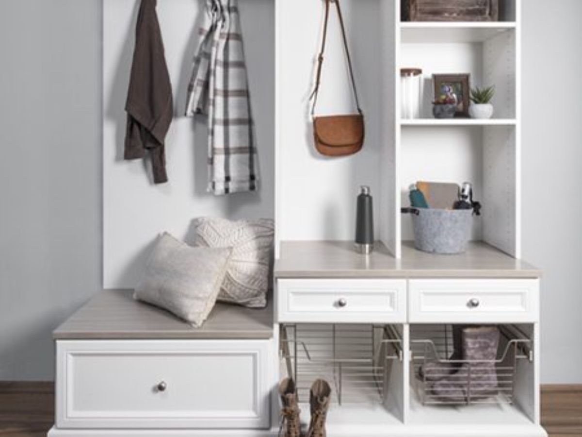 A well-organized walk-in closet with teal cabinetry and white shelving. Clothes hang, and decorative items are on display.