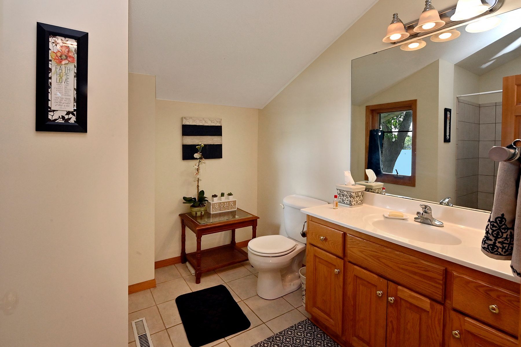 A bathroom with a toilet , sink and mirror