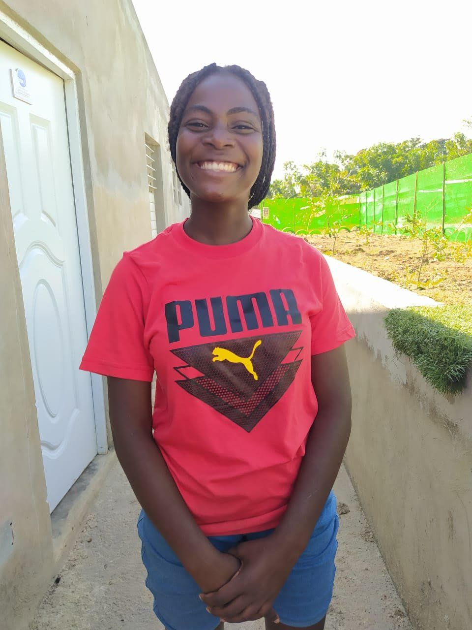 Picture of Melissa standing beside a Kids to Christ Ministry Building in the Dominican Republid