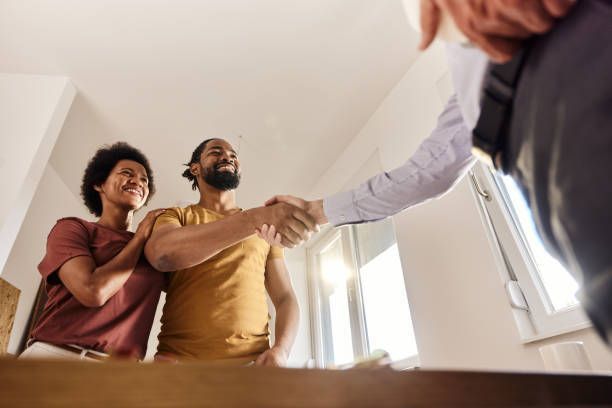 A man is sitting on the ground working on a heat pump.