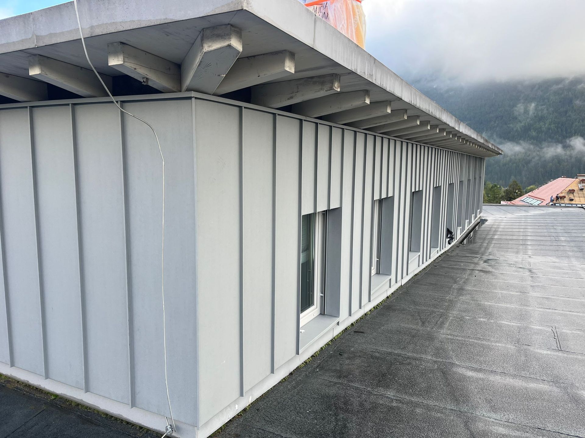 ein weißes Gebäude mit einem schwarzen Dach