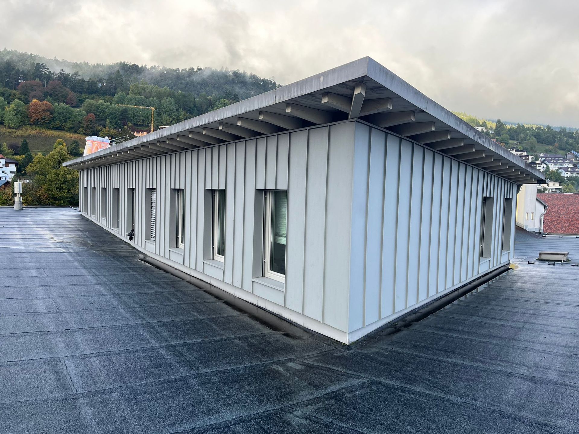 ein Gebäude mit einem schwarzen Dach und einer weißen Fassade