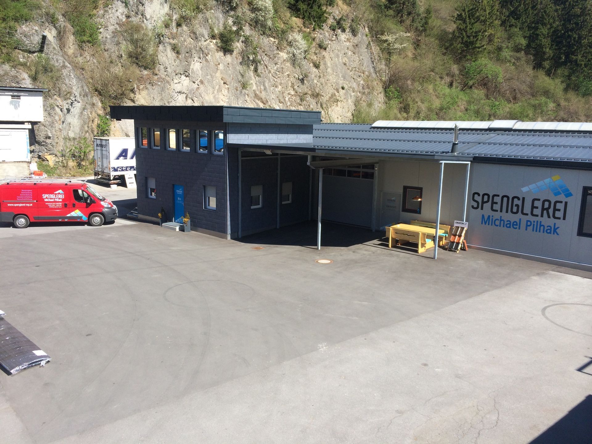 ein spenglerei-Gebäude mit einem roten Lieferwagen davor