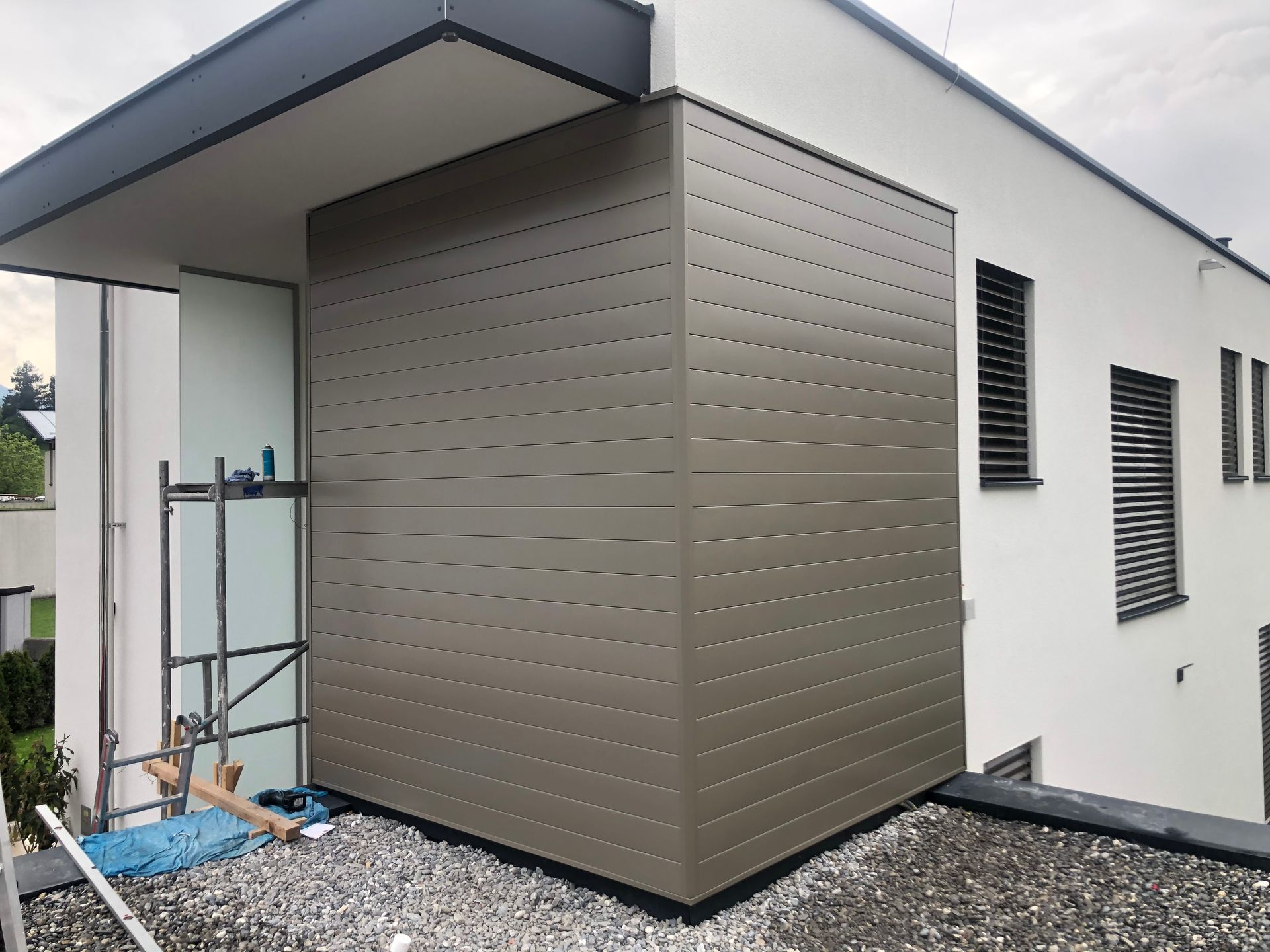 ein weißes Haus mit einer grauen Fassade und Fensterläden