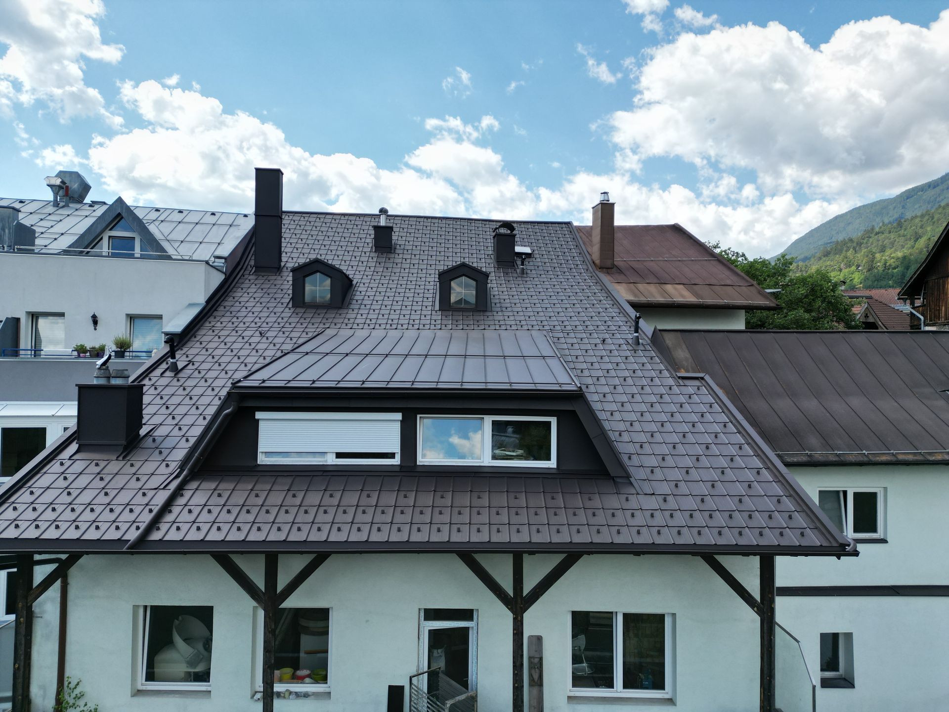 ein weißes Haus mit einem braunen Dach und vielen Fenstern