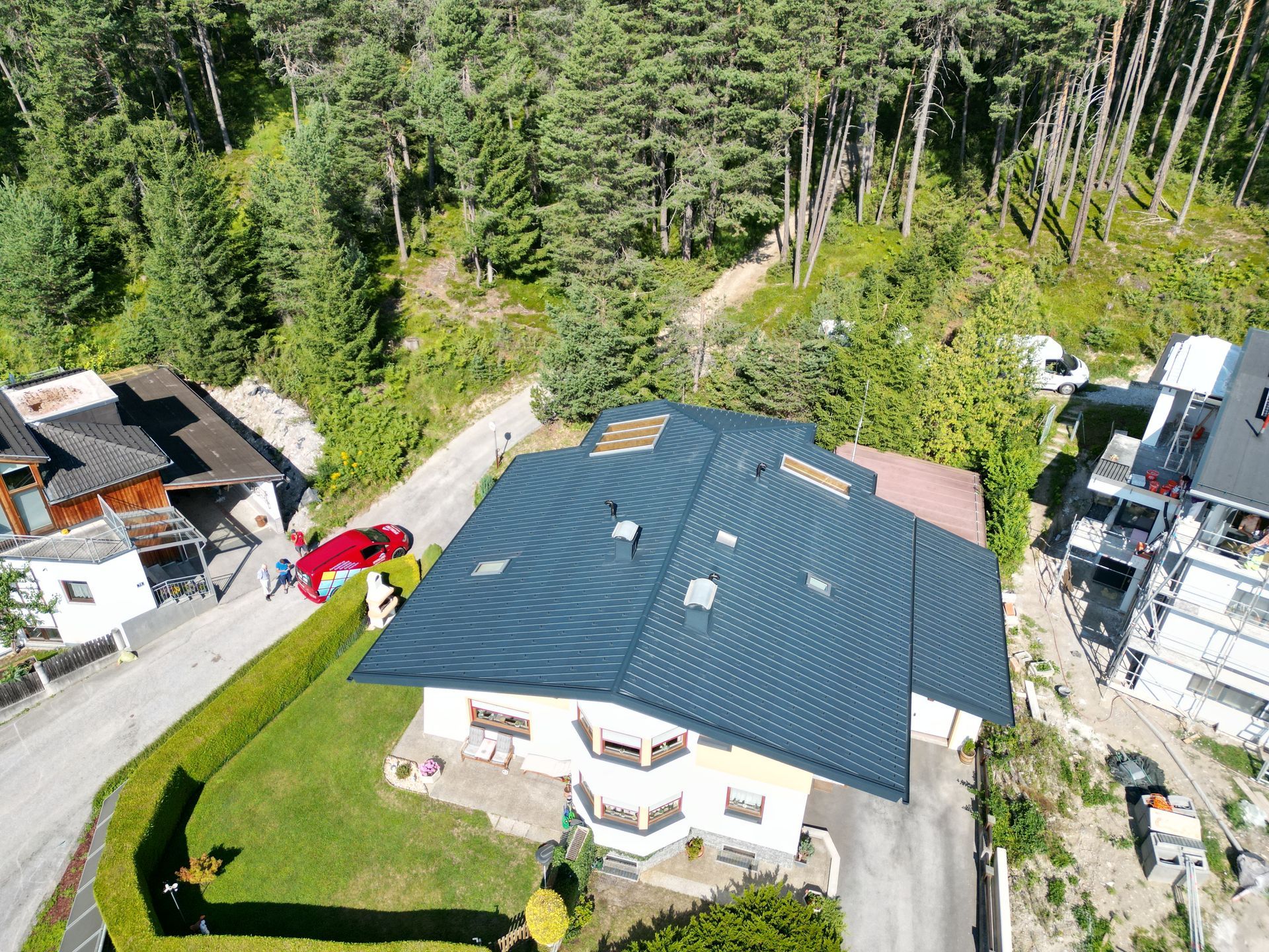 eine Luftaufnahme eines Hauses mit einem roten Auto auf dem Dach