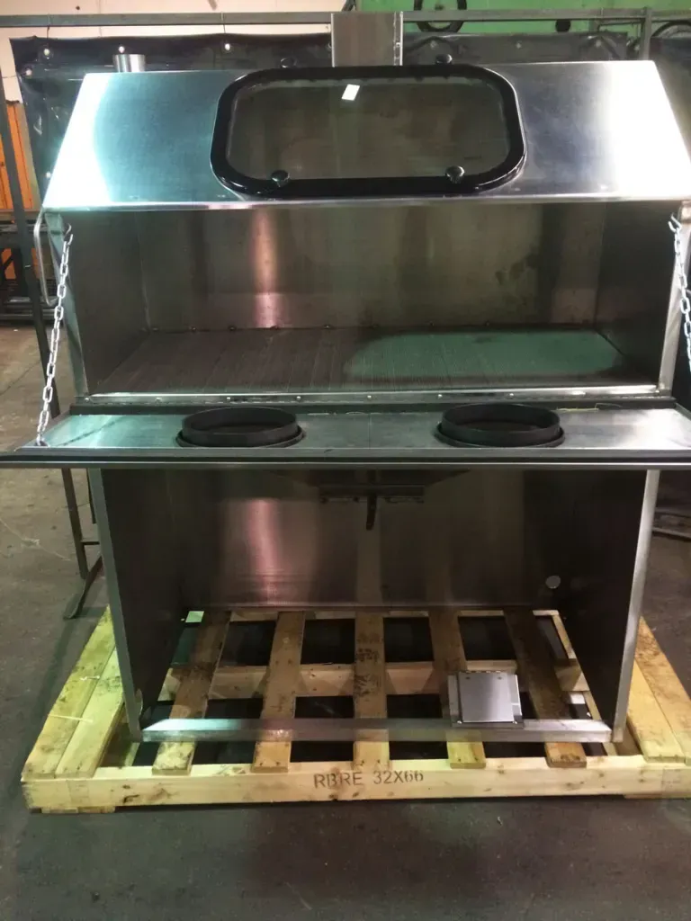 A stainless steel cabinet is sitting on a wooden pallet.
