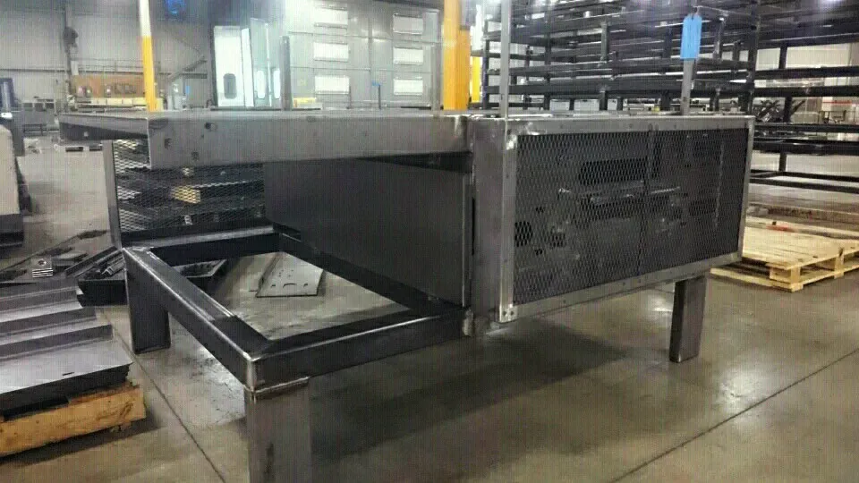 A large metal box is sitting on top of a concrete floor in a warehouse.