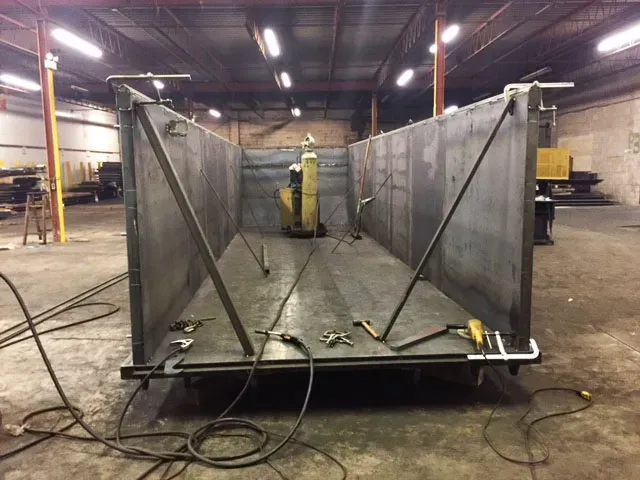 A large piece of metal is being worked on in a warehouse.