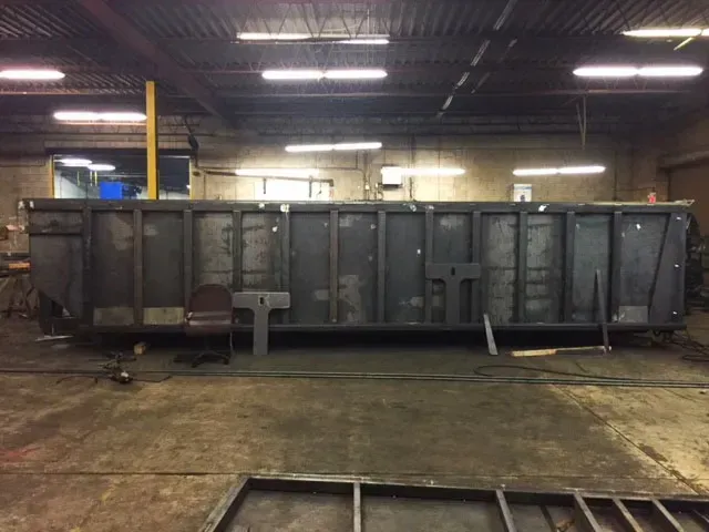 A large metal structure is being built in a warehouse