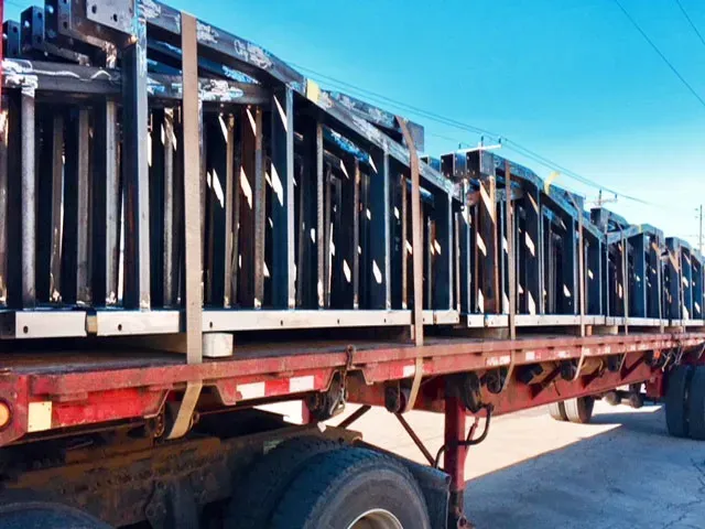 A red semi truck is carrying a large stack of crates