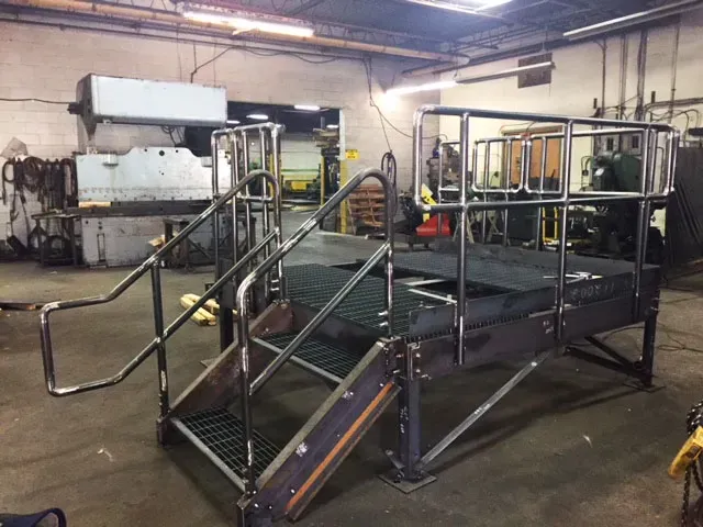 A metal platform with stairs and a railing in a factory