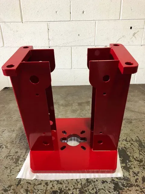 A custom welded and laser cut part, painted red.