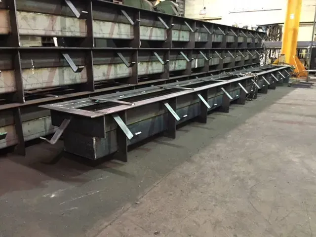A row of metal boxes are lined up in a warehouse.