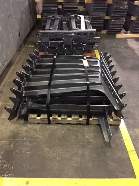 A bunch of metal pieces are stacked on top of each other on a wooden pallet.