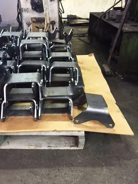 A bunch of metal parts are sitting on a wooden pallet