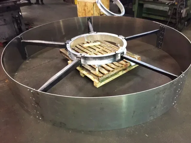 A large metal ring is sitting on top of a wooden pallet.