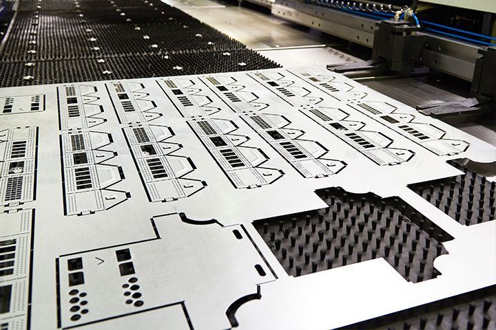 A machine is cutting a piece of metal in a factory.