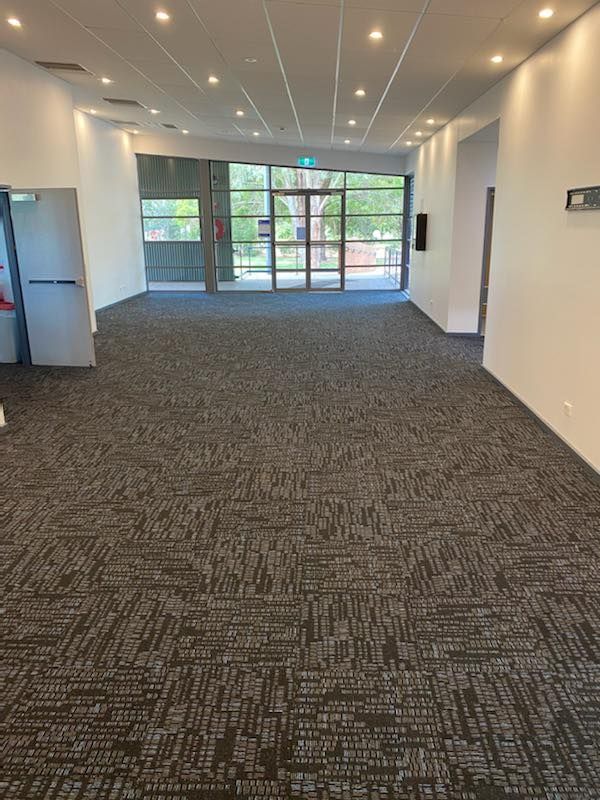 A Large Empty Room With A Black Carpet And White Walls — Cabonne Carpets In Molong, NSW