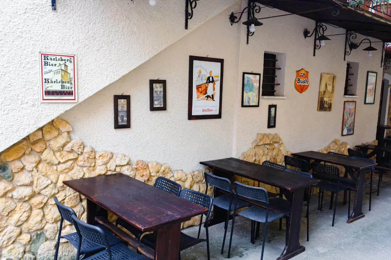 Un ristorante con tavoli e sedie di fronte a un muro di pietra.