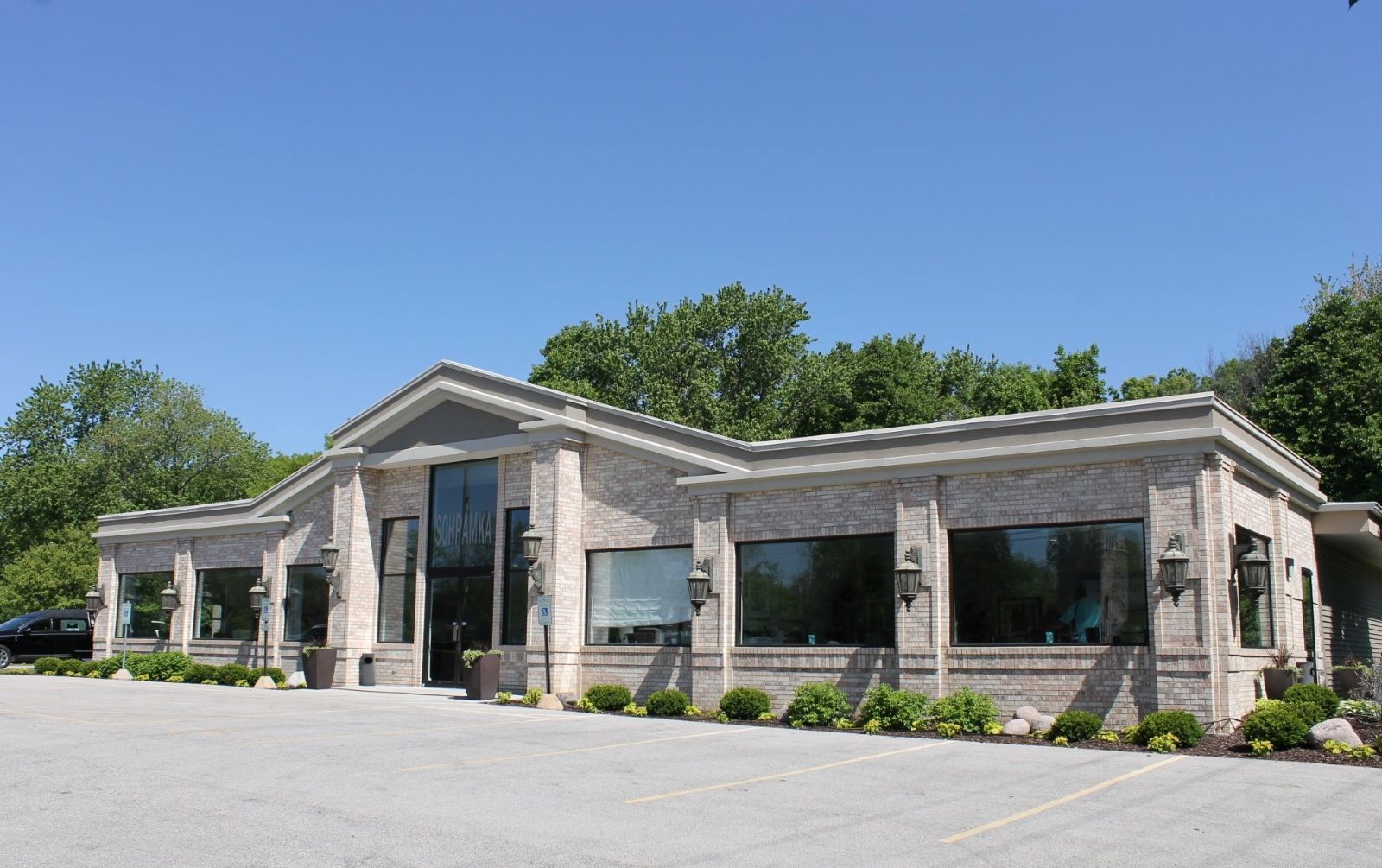 Brick building with large windows and a clear blue sky.