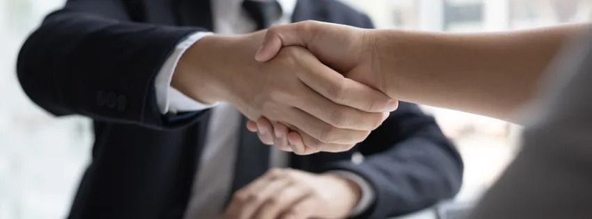 Two people shaking hands, likely during a business deal or agreement.