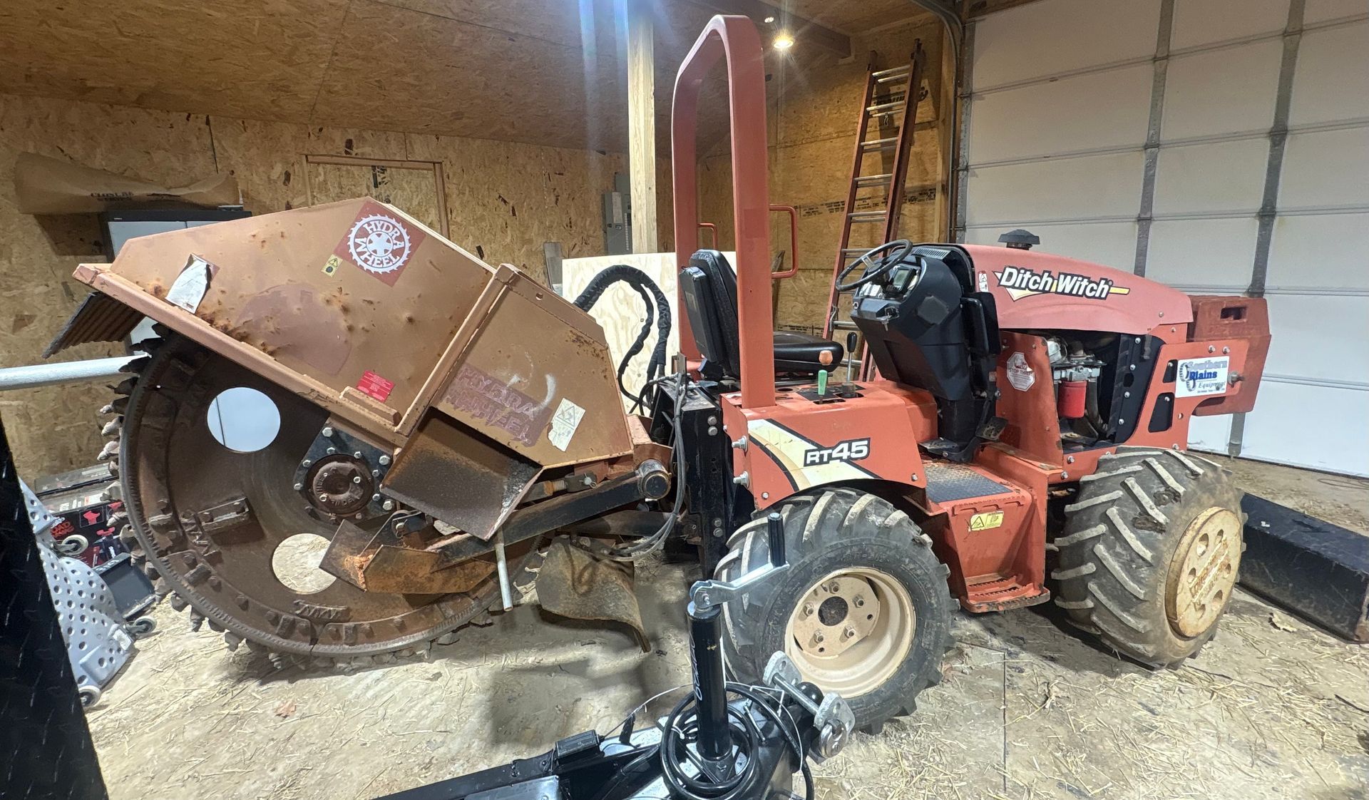 An excavator is digging a trench in front of a house