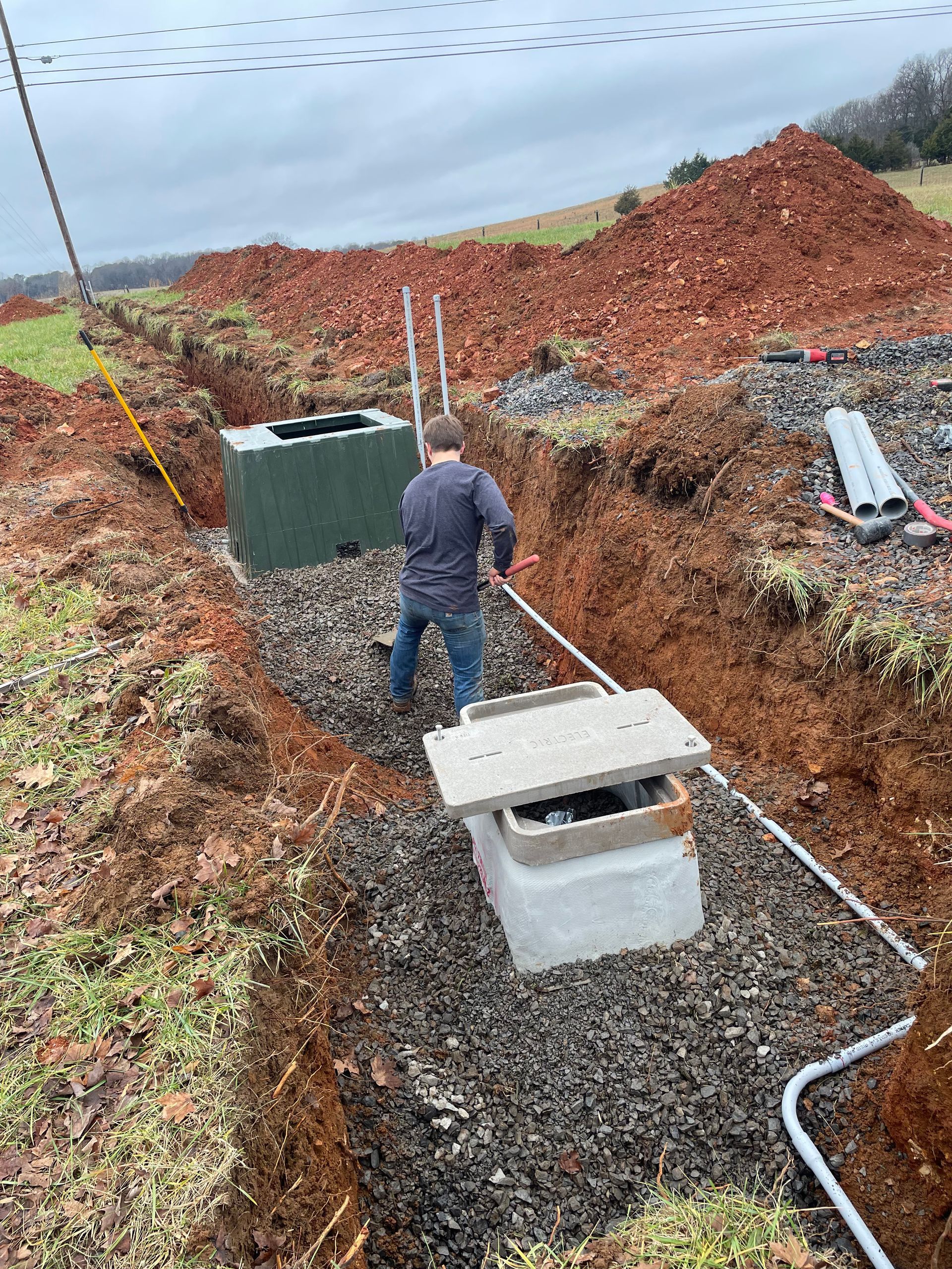 A man is digging a hole in the dirt in a field.
