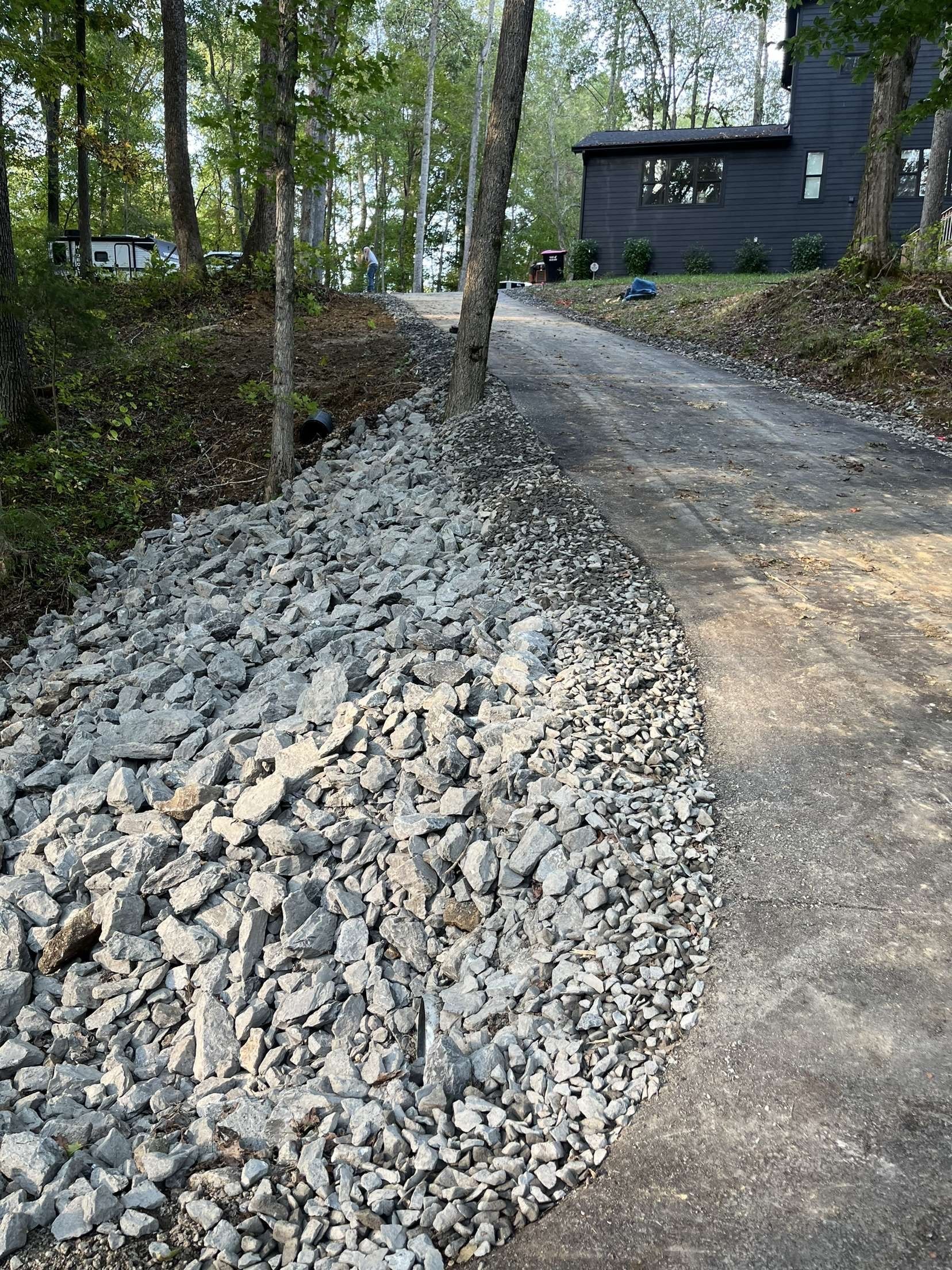 A pile of rocks along the side of a dirt road.