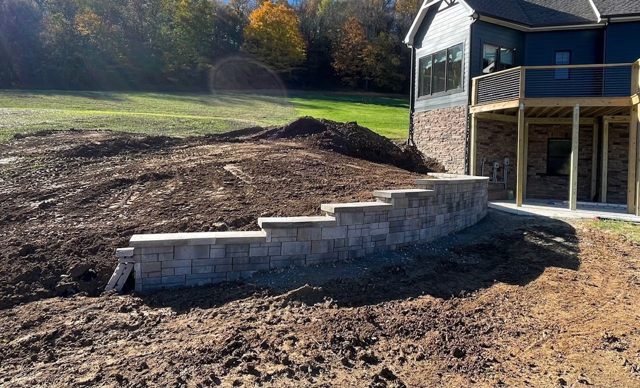 A brick wall is being built in front of a house.