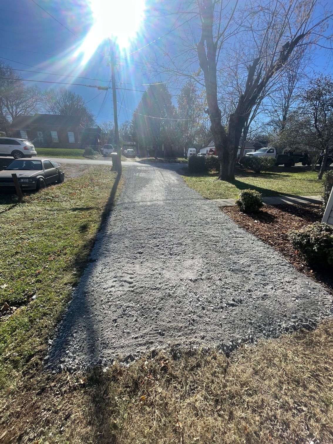 A gravel path leading to a house on a sunny day.