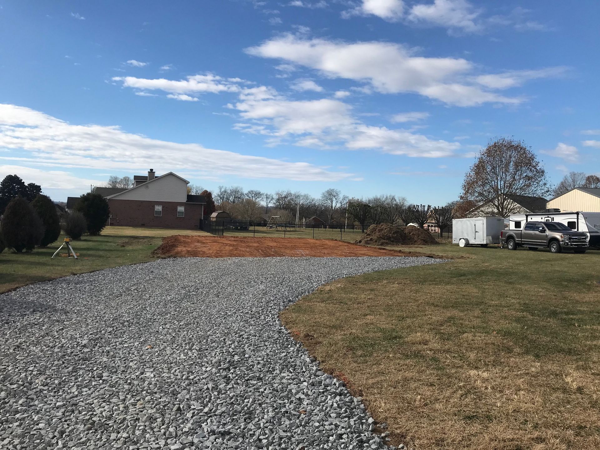 A gravel driveway leading to a house in a residential area.