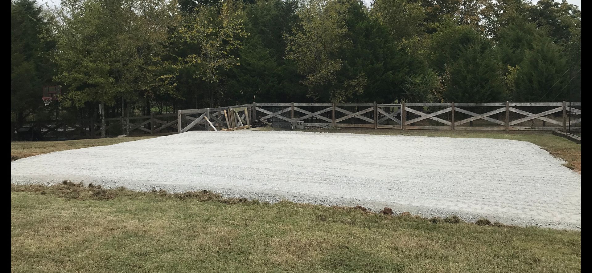A large white blanket is sitting in the middle of a grassy field.