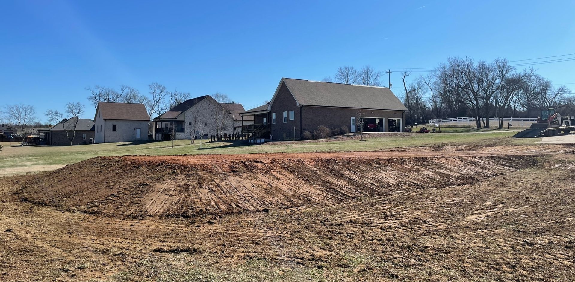 A house is sitting in the middle of a dirt field.