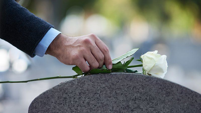 placing rose on grave