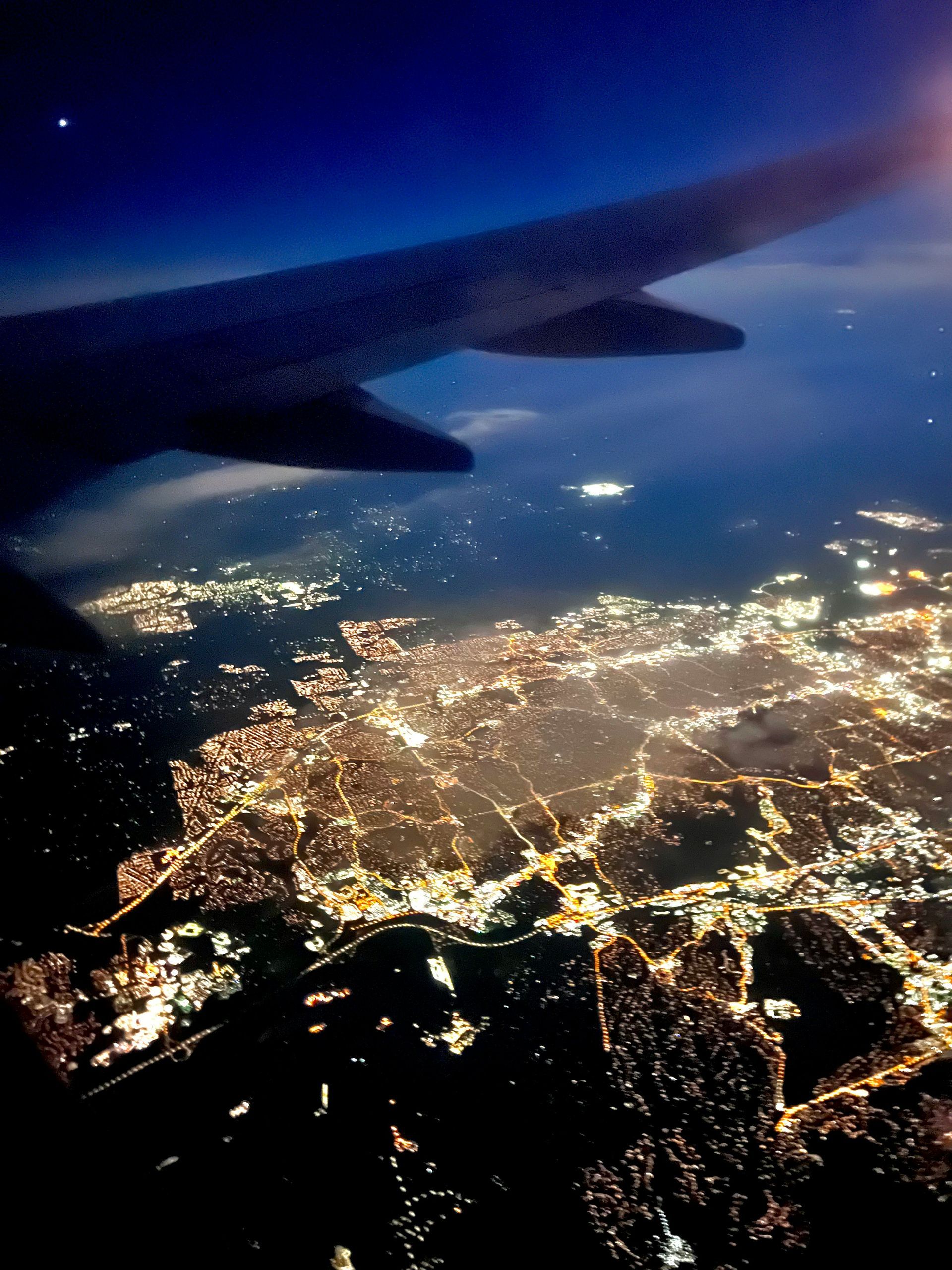 An airplane view of the city lights at night.