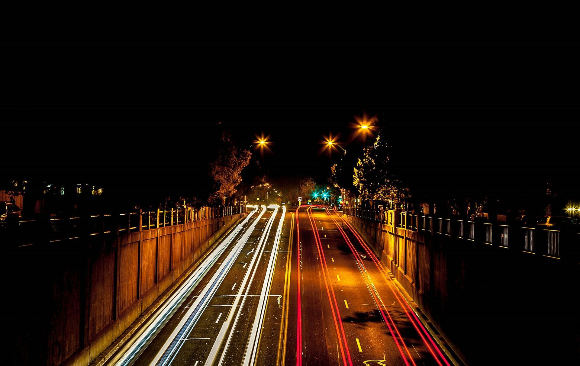 Colorado Springs bridge at night with a view of the night lights, streetlamps, and cars passing by.