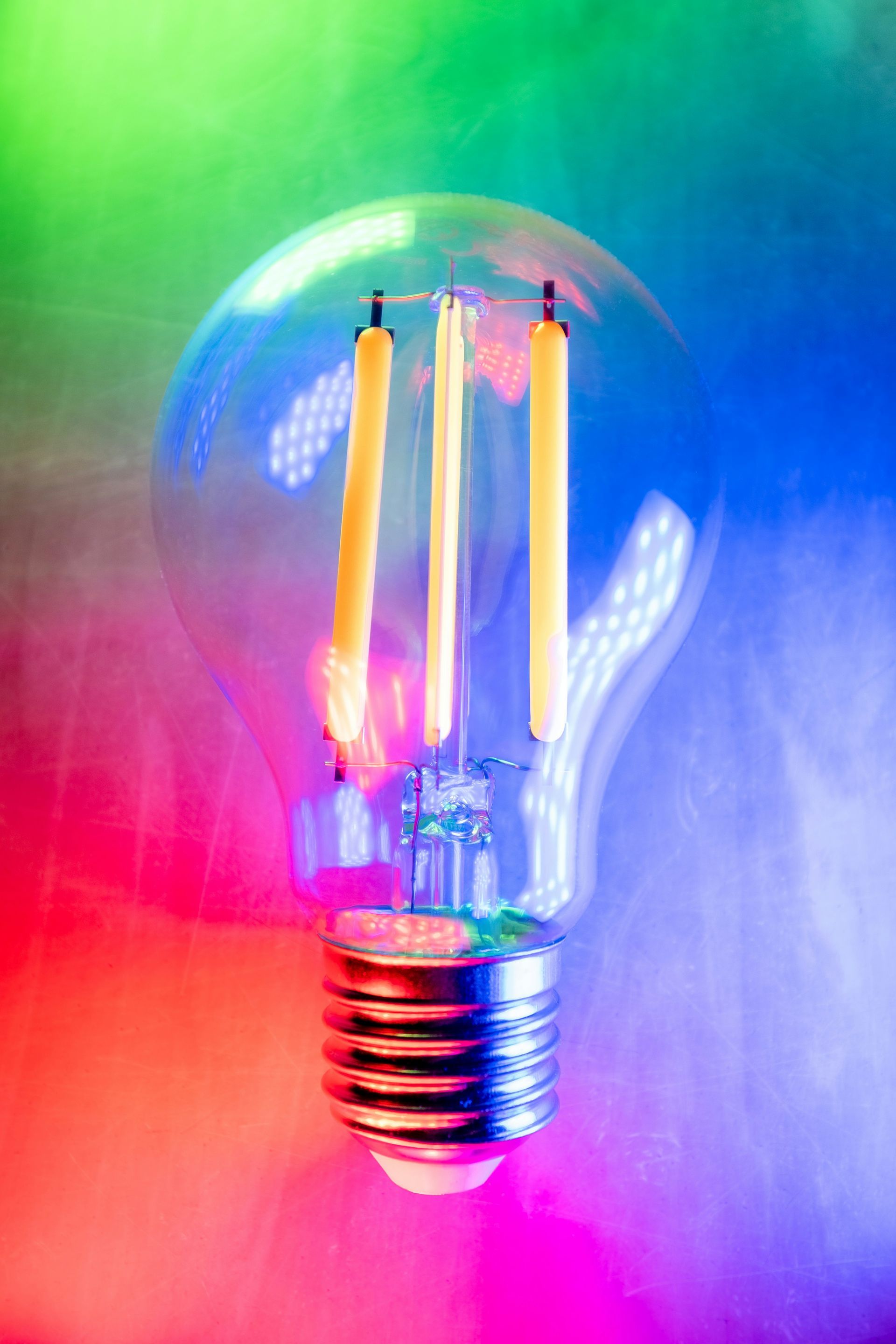 A lightbulb that is an LED lightbulb surrounded by different colors of light.