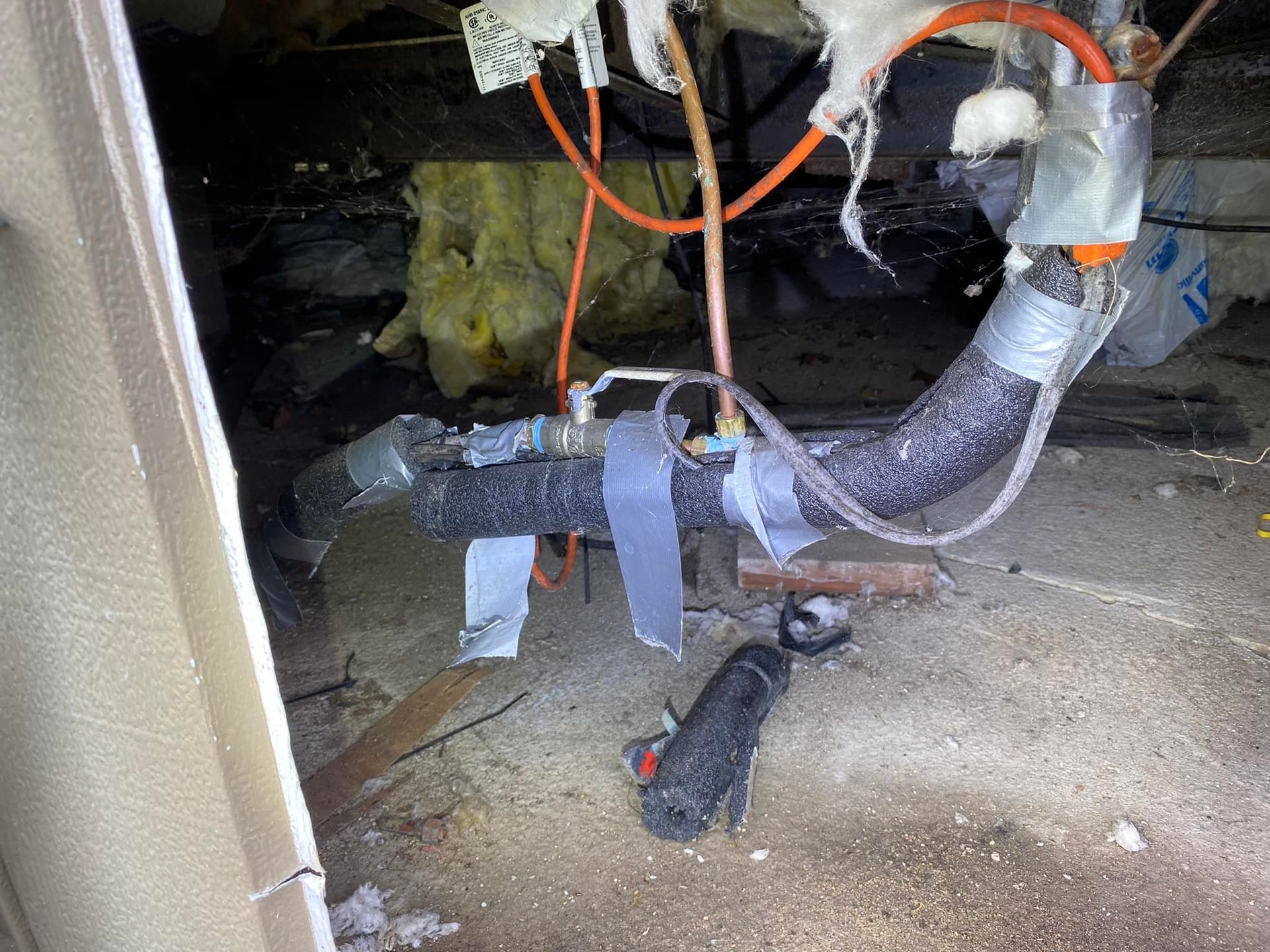 A bunch of wires are hanging from a pipe in a room