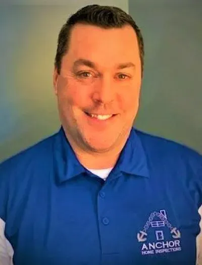 A man in a blue shirt is smiling for the camera.