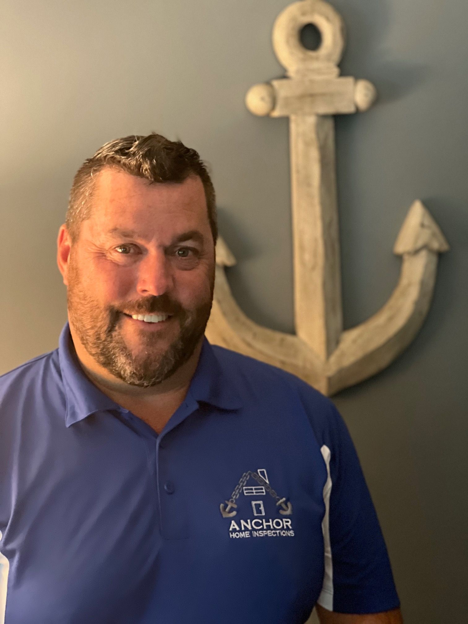 A man in a blue shirt is smiling for the camera.