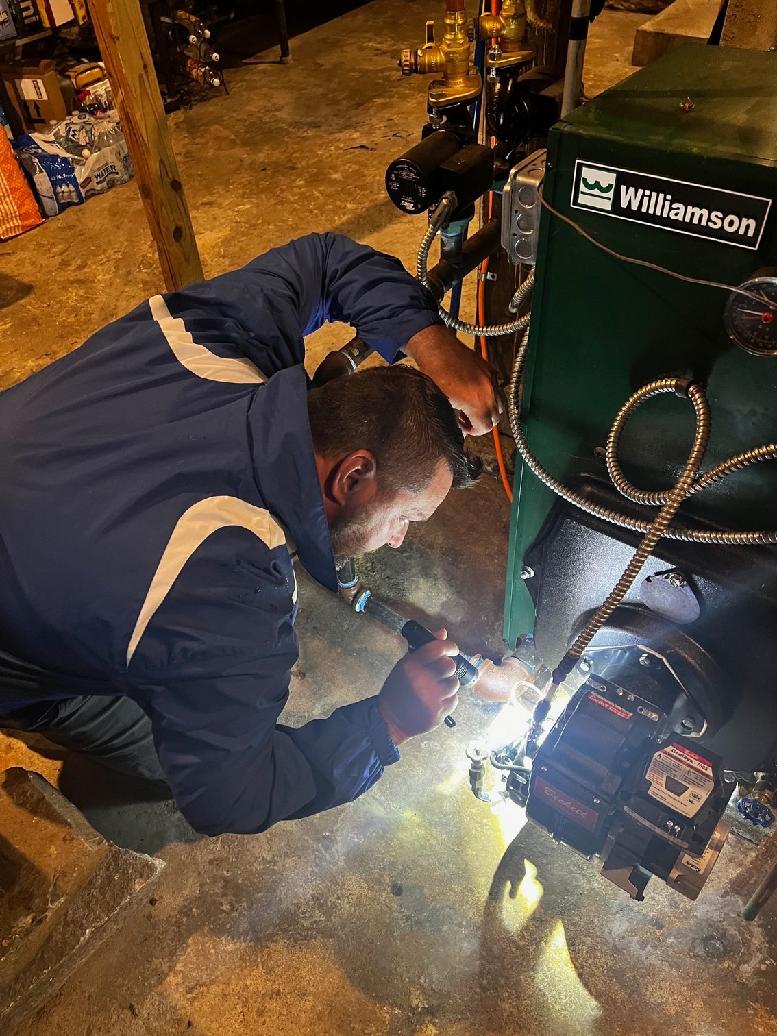 A bunch of wires are hanging from a pipe in a room