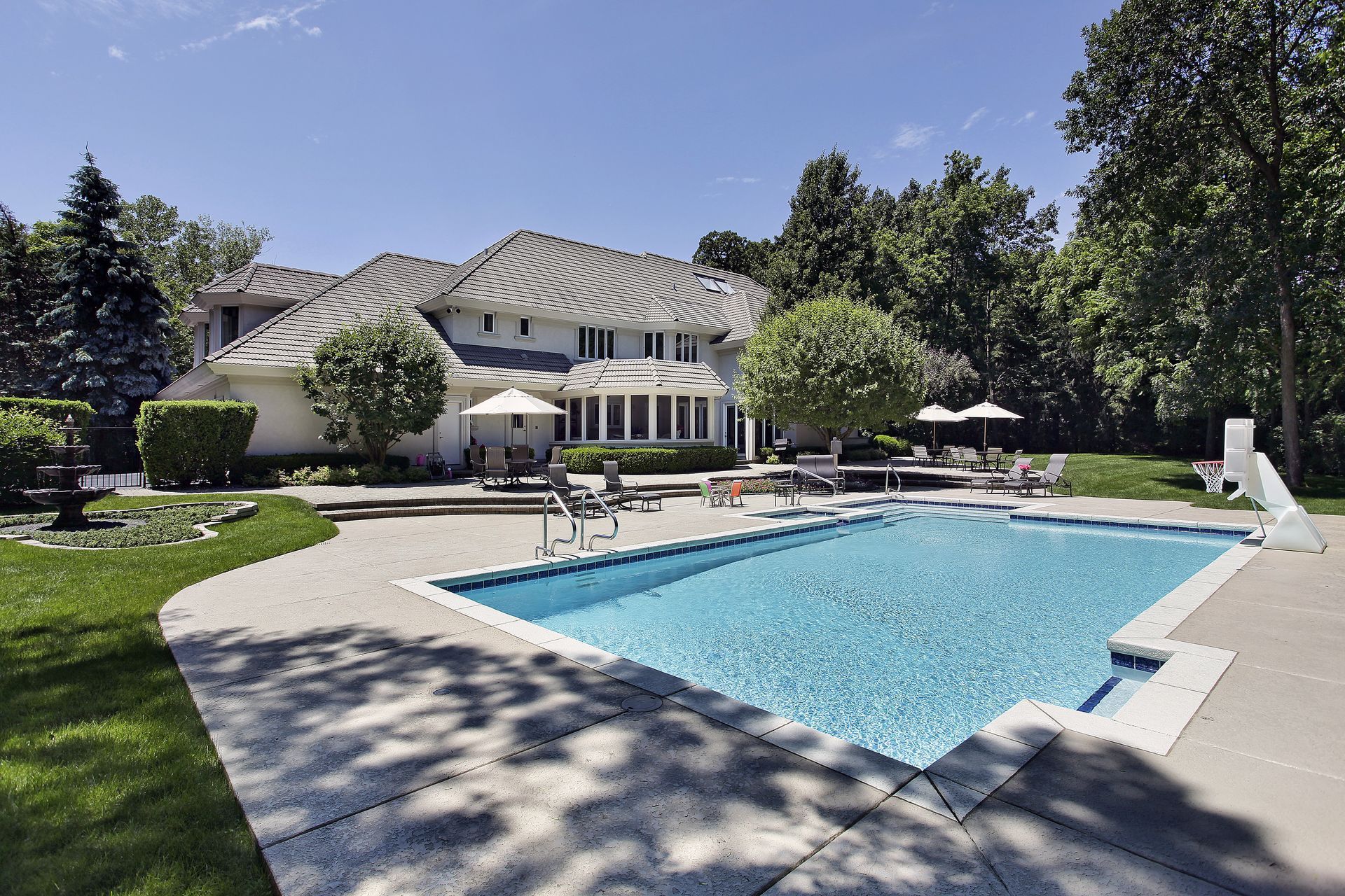 A large house with a large swimming pool in front of it