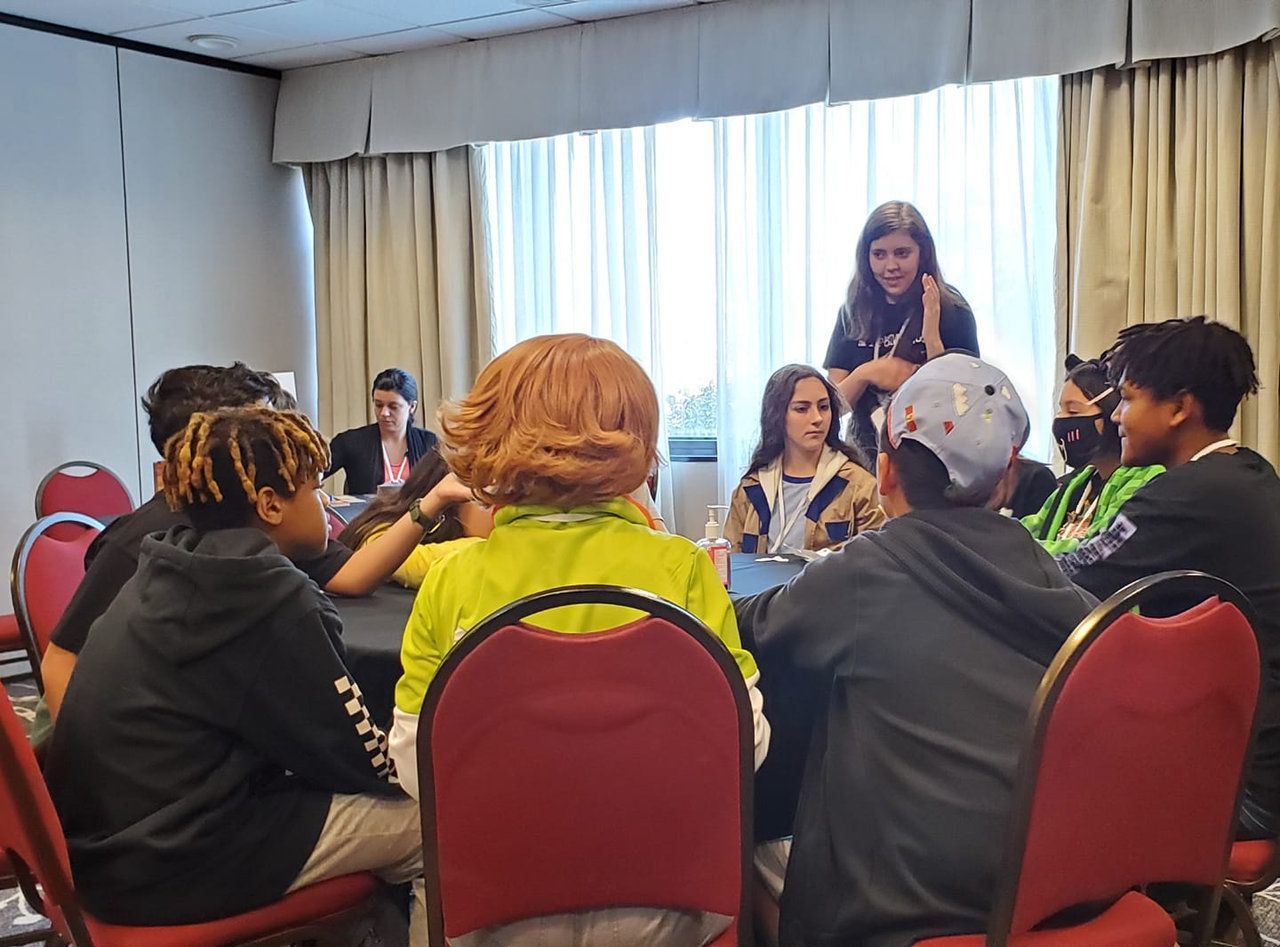 A group of people are sitting around a table in a room.
