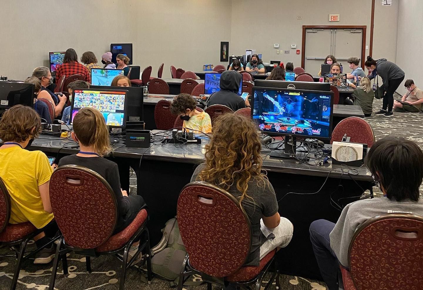 A group of people are sitting at tables playing video games.