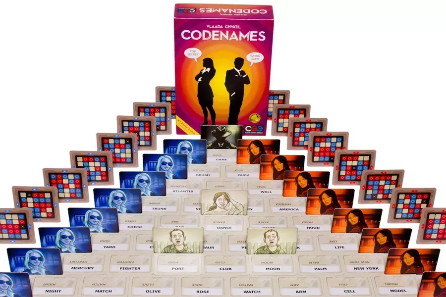 Codenames board game with a grid of word cards on the table, teams working to solve word clues.