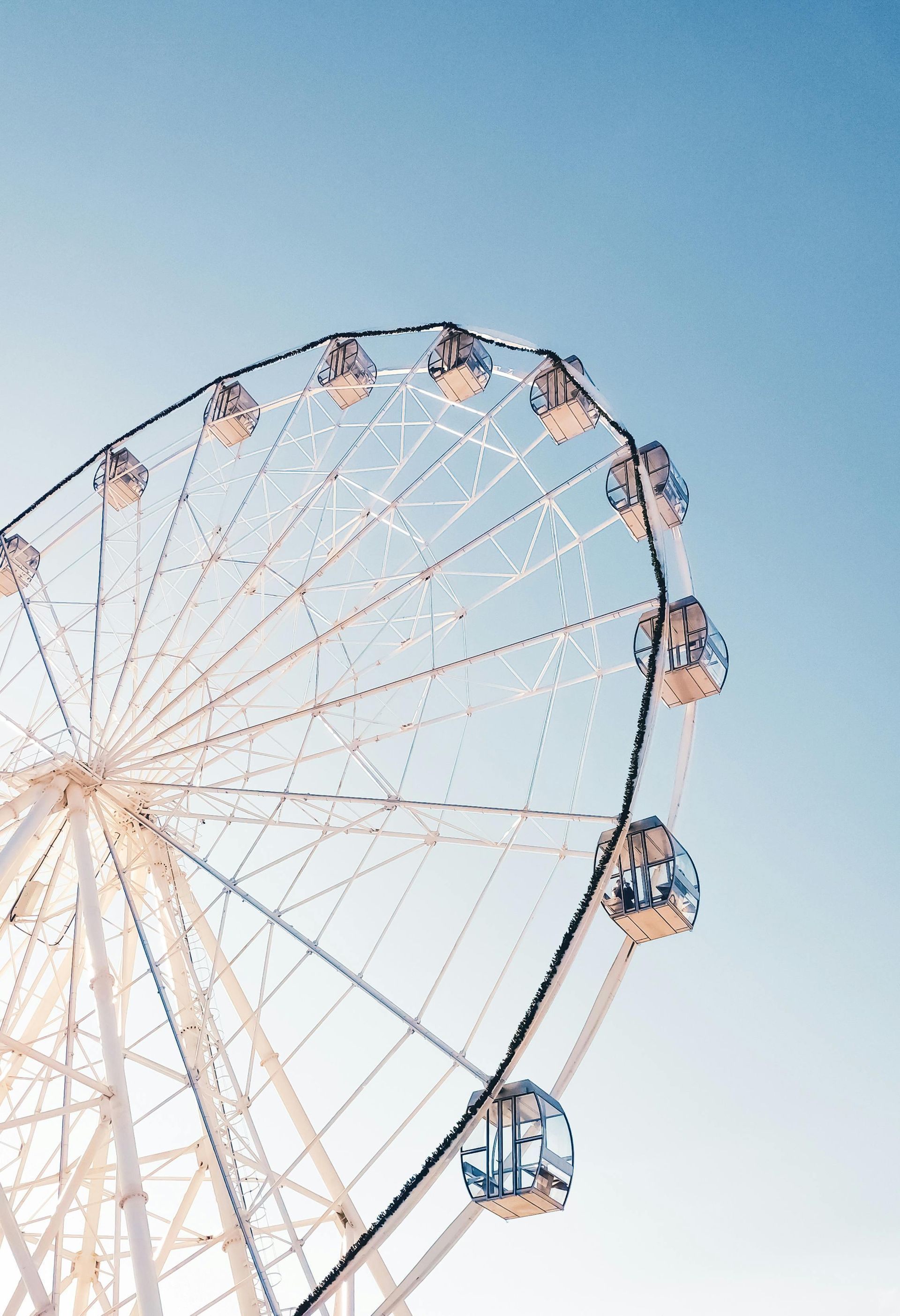 A ferris wheel is against a blue sky.