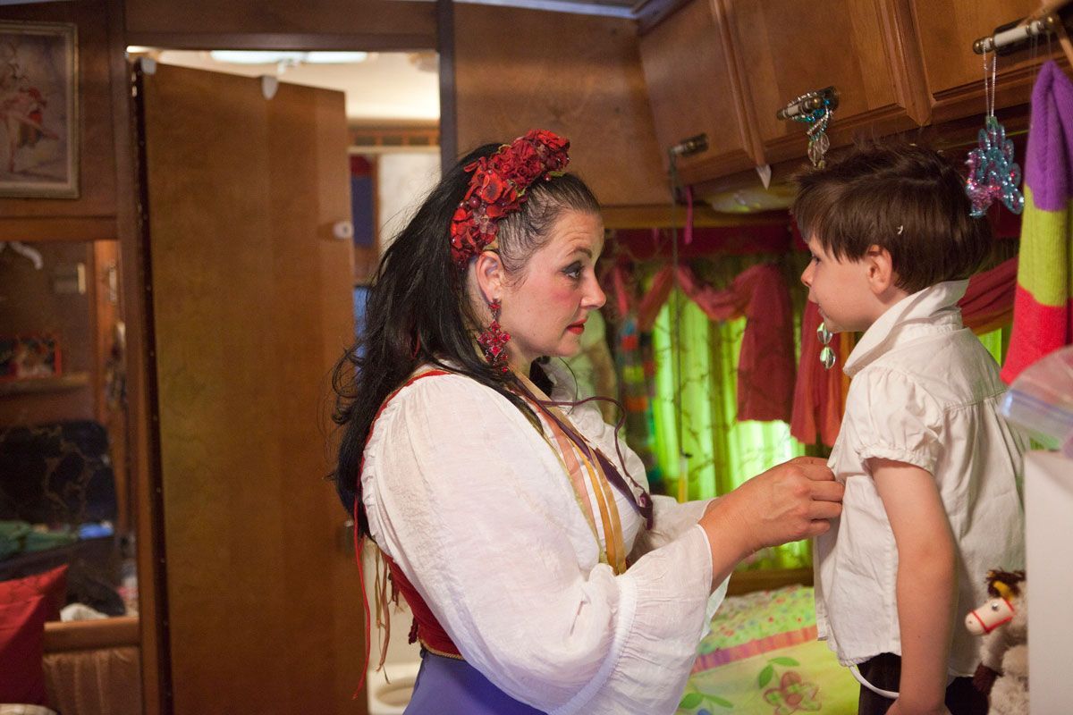 Tosca helps her nephew, Julien, get into his costume before the first show of the day. 