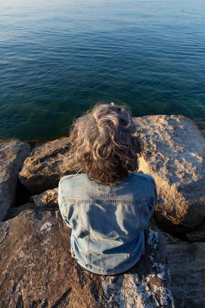 Older woman with silver hair sitting by the lake in Chicago